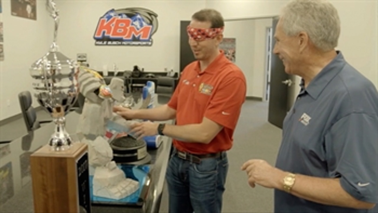 Kyle Busch shows Darrell Waltrip where he keeps his 200+ NASCAR trophies