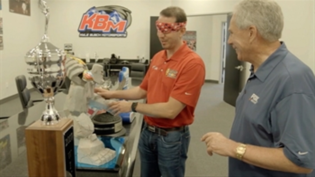 Kyle Busch shows Darrell Waltrip where he keeps his 200+ NASCAR trophies