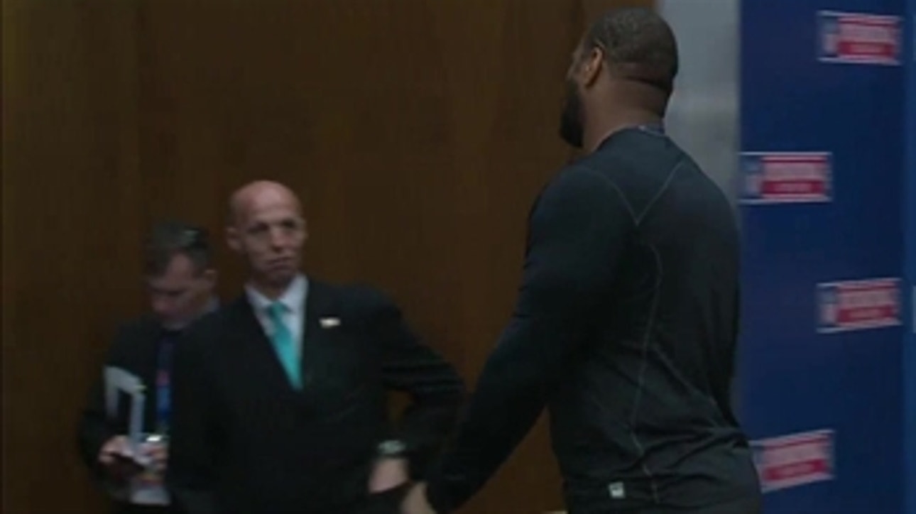 Staffer Gives Suh a smirk as he walks out of press conference in London