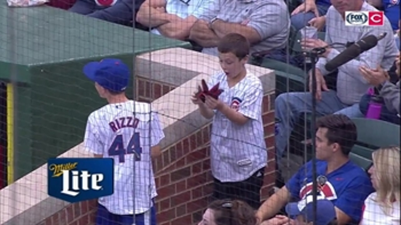Joey Votto tosses his batting gloves to young Cubs fans