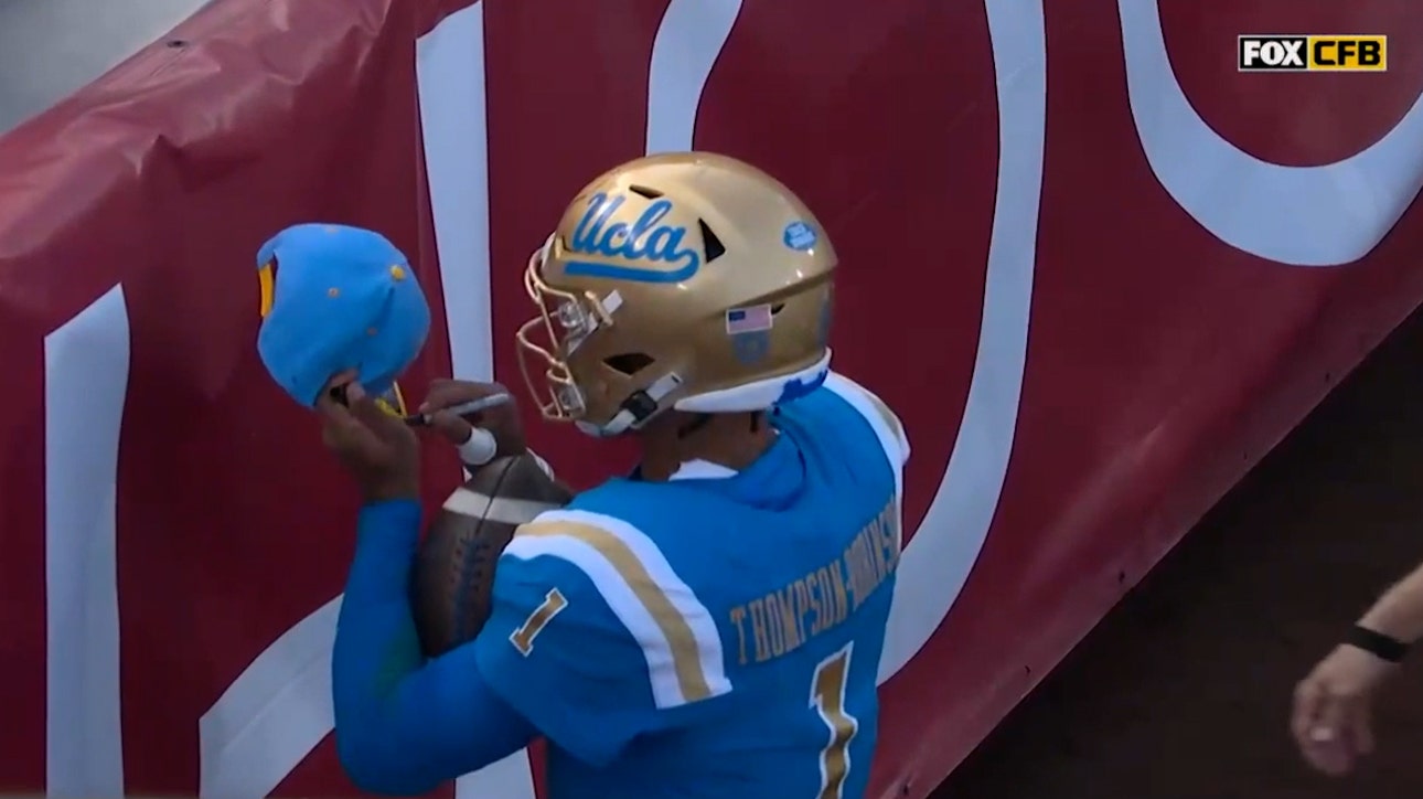 Dorian Thompson-Robinson signs fan's hat after four-yard rushing touchdown