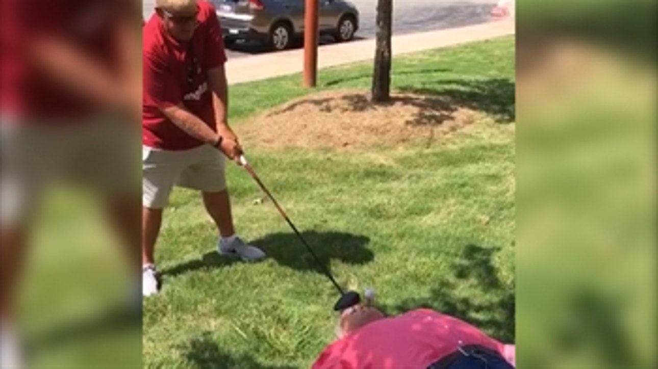 John Daly hits a golf ball from a guy's mouth