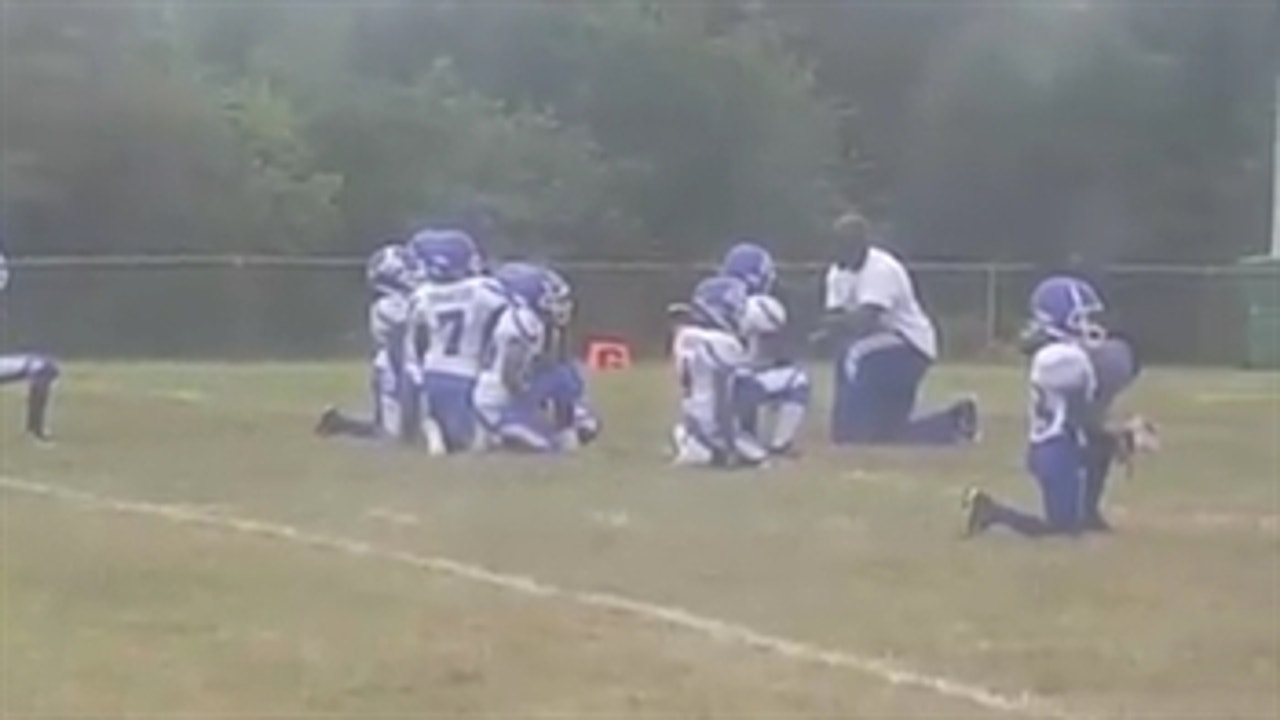 Youth football team takes knee during the national anthem