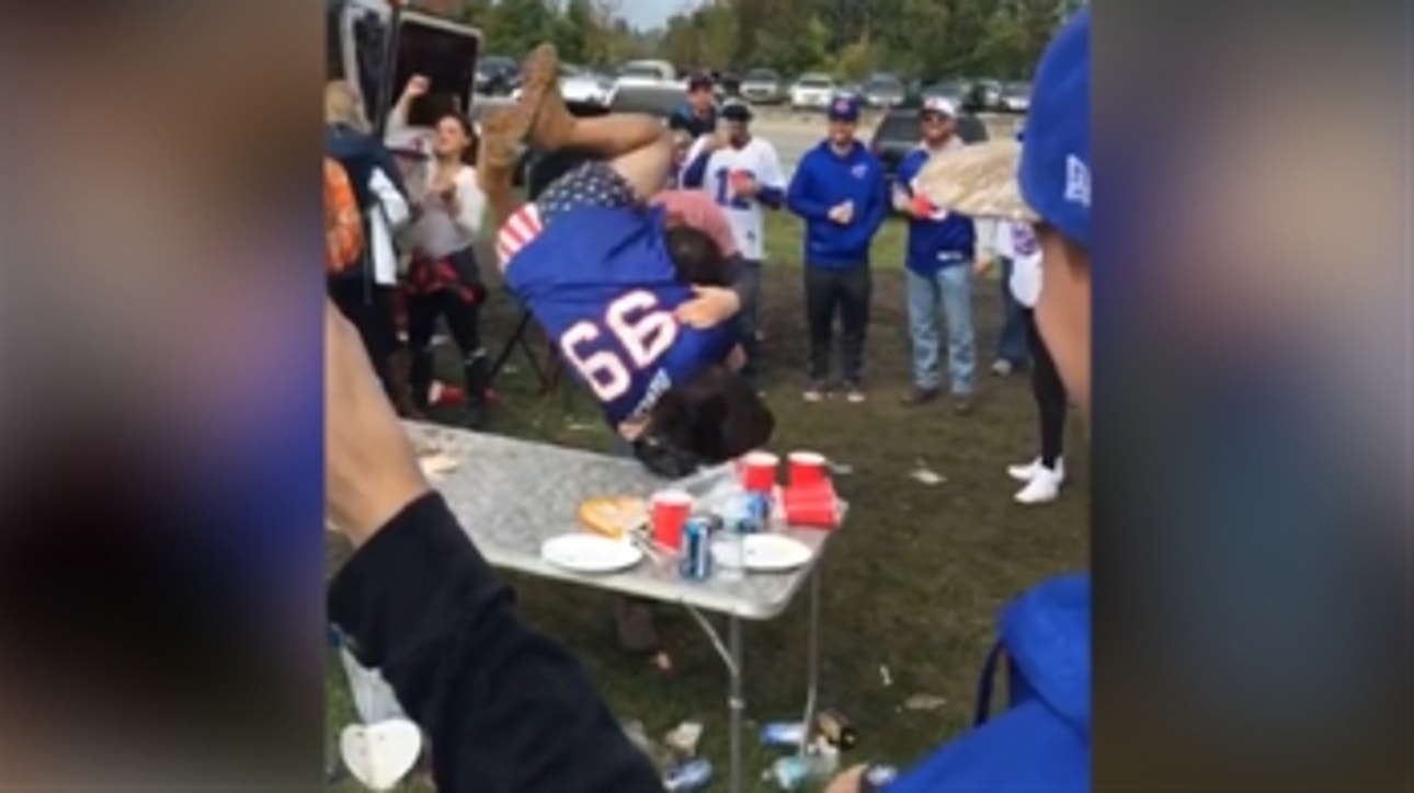 Watch a tailgating Bills fan body slam his friend through a table
