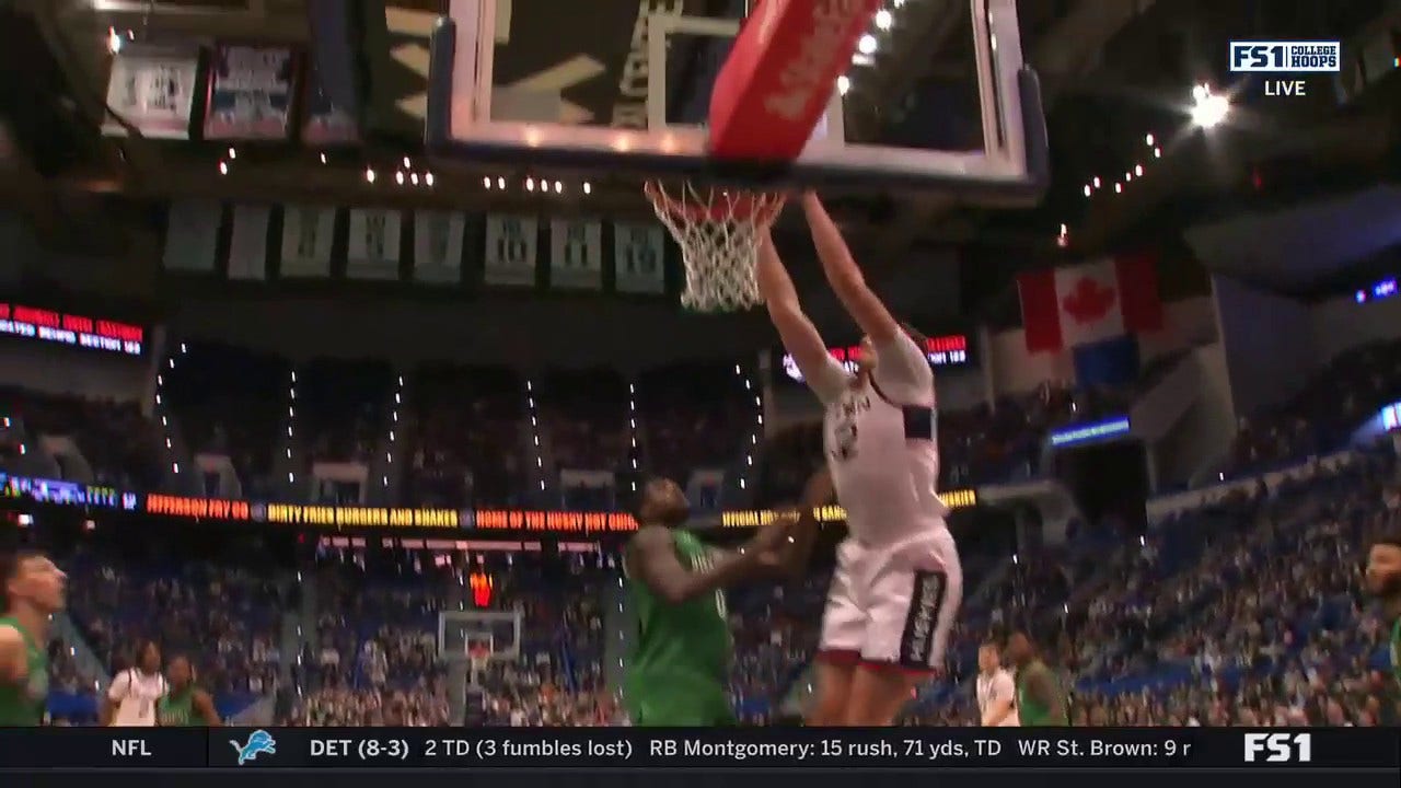 Donovan Clingan spins and two-hand dunks the ball to extend UConn’s lead over Manhattan
