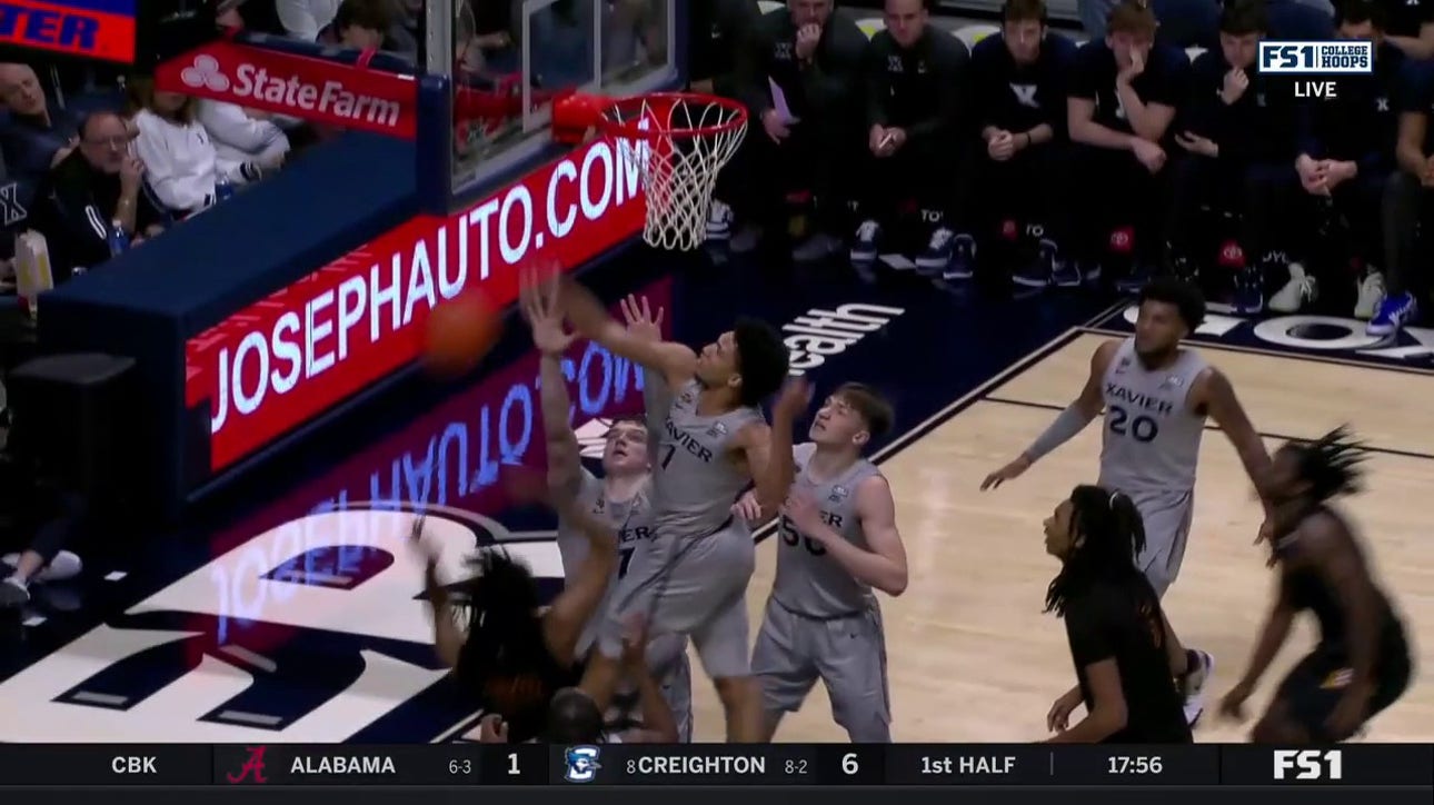 Desmond Claude soars and swats the ball into the stands to protect Xavier's lead against Winthrop