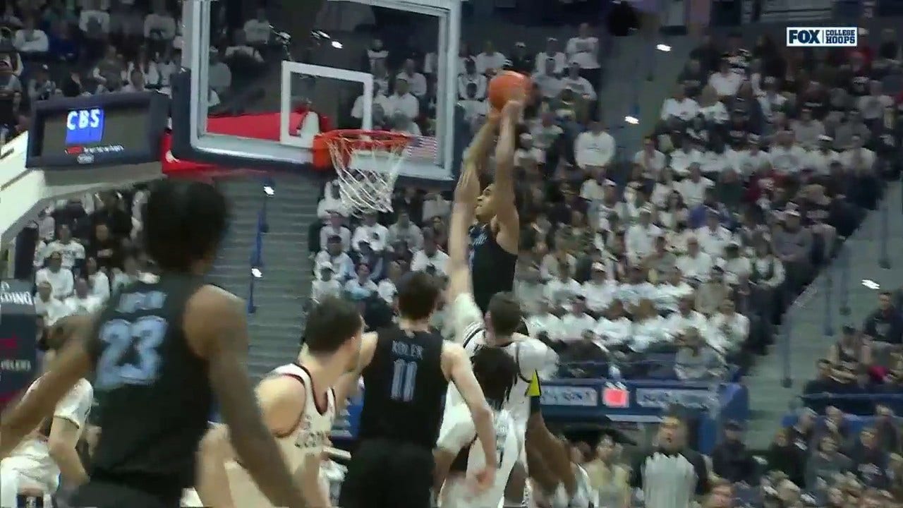 Marquette's Oso Ighodaro skies for the two-handed alley-oop against UConn