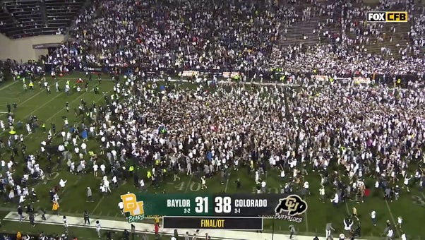 Fans storm the field after Colorado's Travis Hunter forces a Baylor fumble through the endzone and seals a 38-31 win in OT