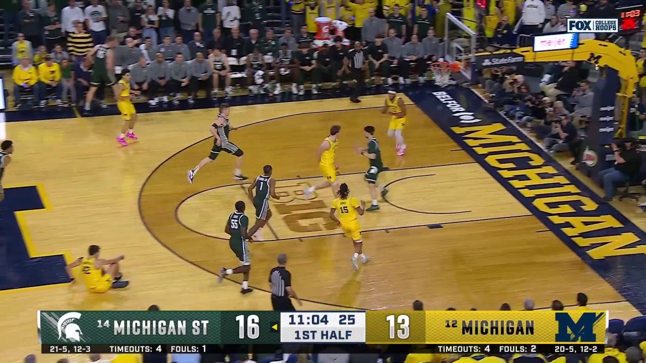 Danny Wolf dari Michigan terhubung dengan Roddy Gayle Jr. untuk Finish Showtime vs Michigan State