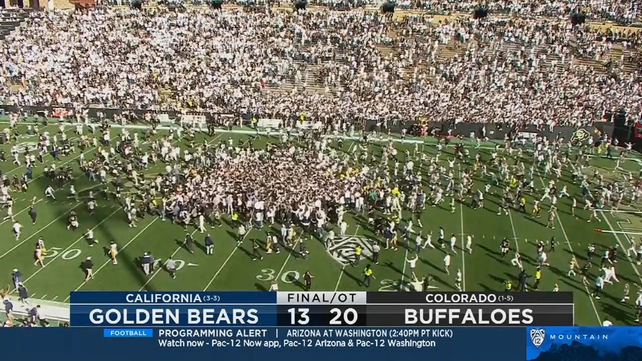 Fans storm the field after Colorado defeated Cal in overtime for their first win of the season