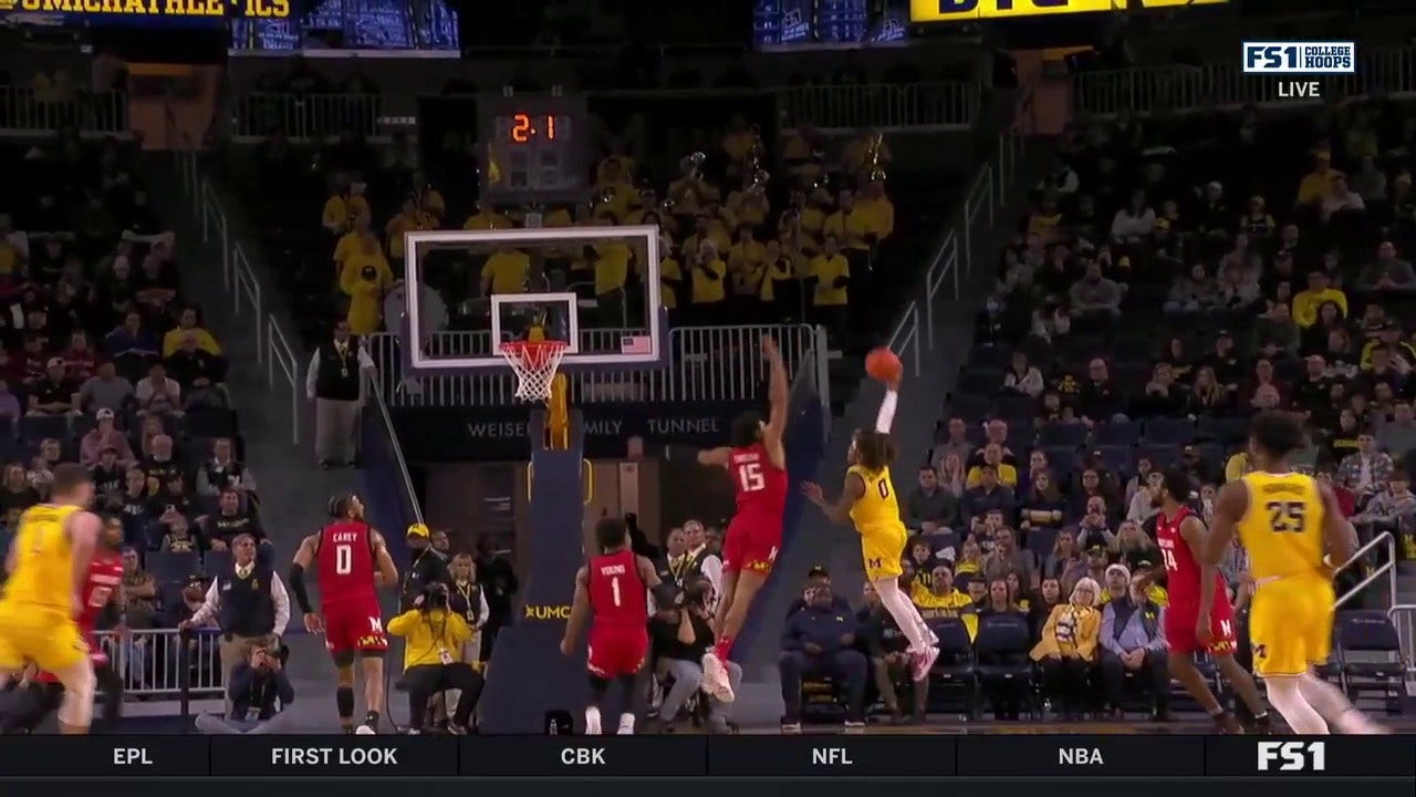 Michigan's Dug McDaniel runs the court and hits the acrobatic layup to end the half