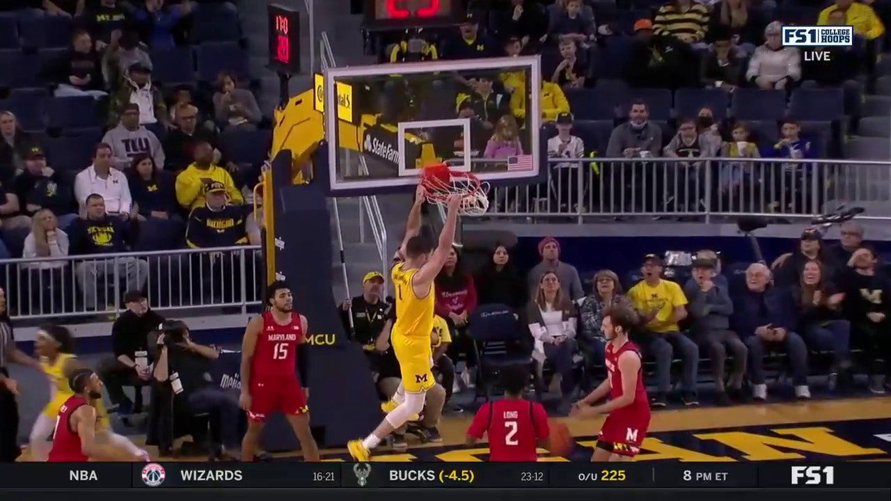 Michigan's Hunter Dickinson runs through the lane and throws down the two-handed slam