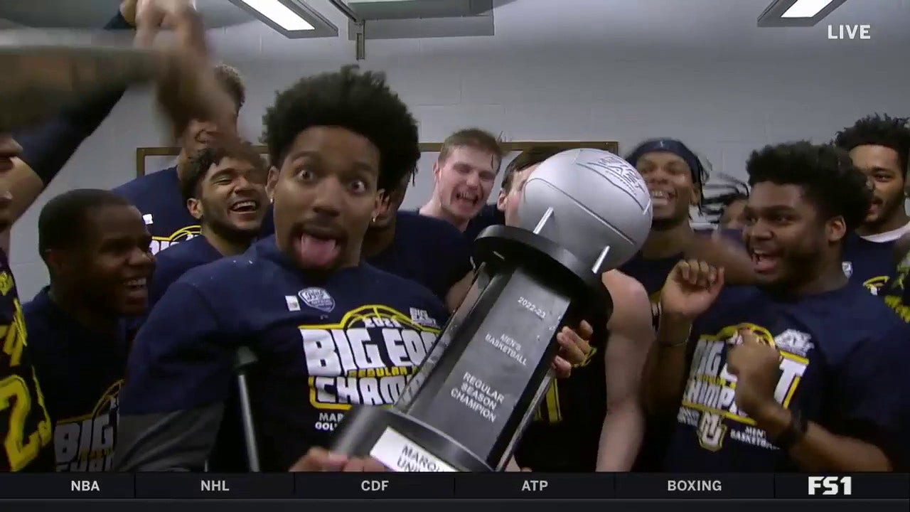 Marquette men's hoops team celebrates in the locker room after clinching their first outright Big East title in school history