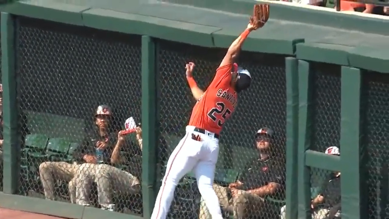 Orioles' Anthony Santander braces the wall, snagging a fly ball to get out of the first inning vs. the Royals