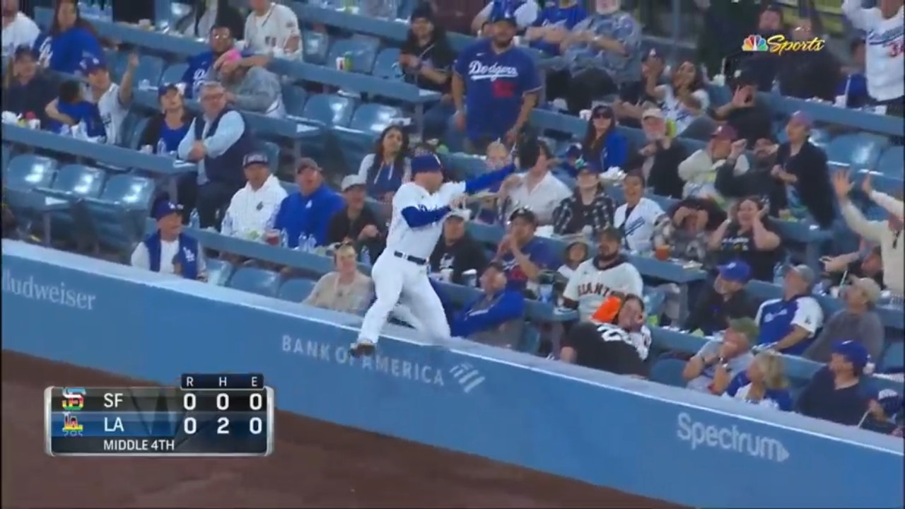 Dodgers' Freddie Freeman makes a leaping catch into the net to get out of the fourth inning