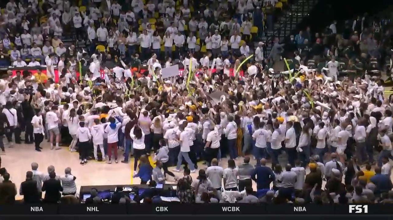 Wyoming fans storm the court after the Cowboys' overtime win against Colorado State