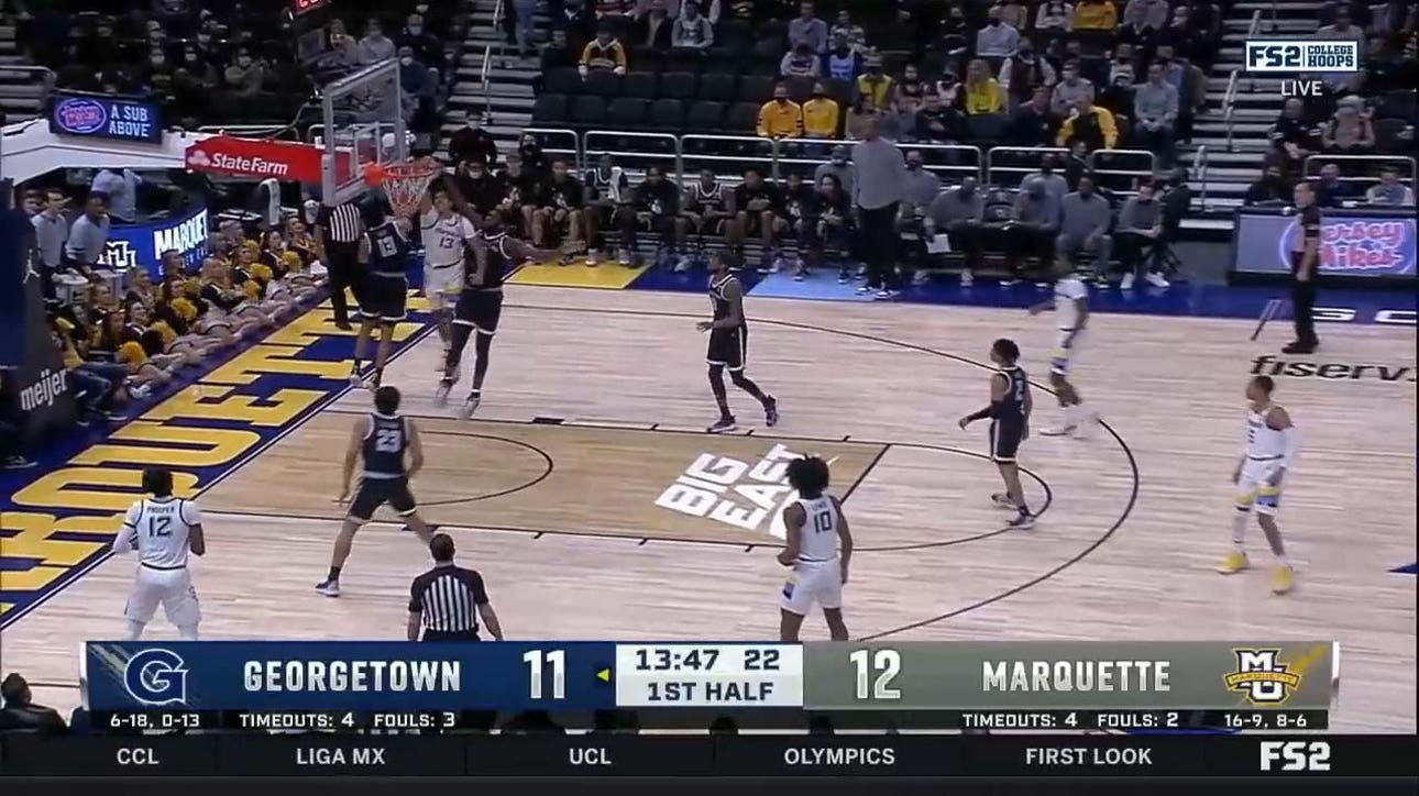 Marquette's Oso Ighodaro throws down a mean one-handed slam against two Georgetown defenders