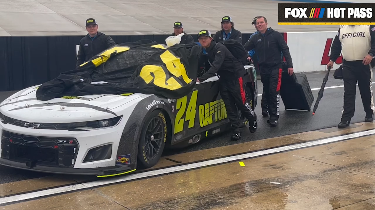 Cars being pushed to the garage at Dover after the rain postpones the race to Monday