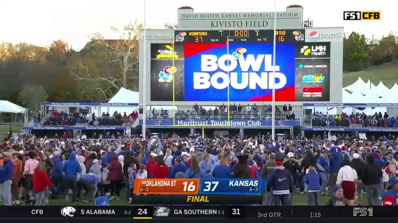 Kansas Jayhawks fans storm the field after they beat the Oklahoma State Cowboys 37-16