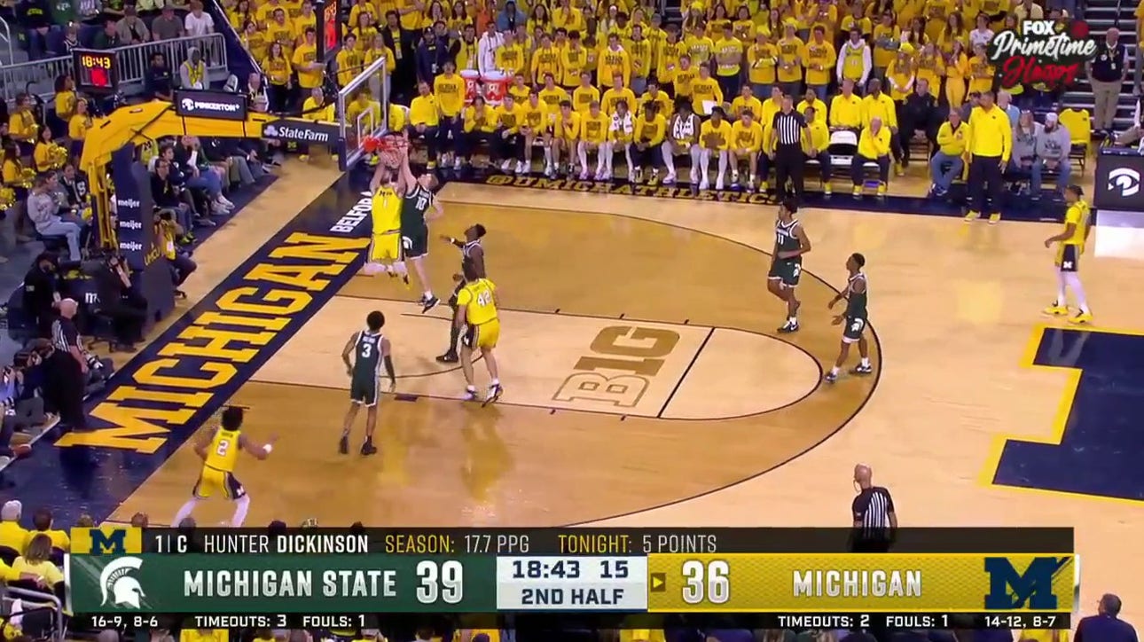 Michigan's Hunter Dickinson delivers a two-handed jam against Michigan State