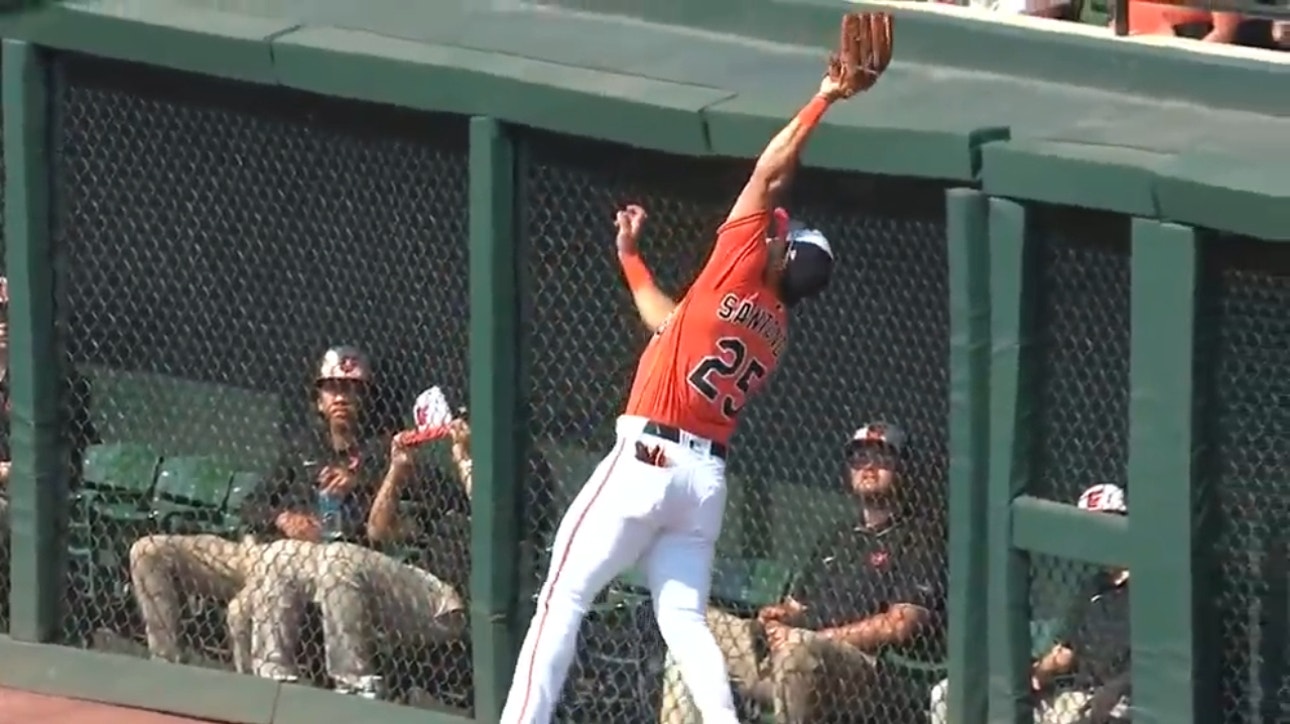 Orioles' Anthony Santander braces the wall, snagging a fly ball to get out of the first inning vs. the Royals