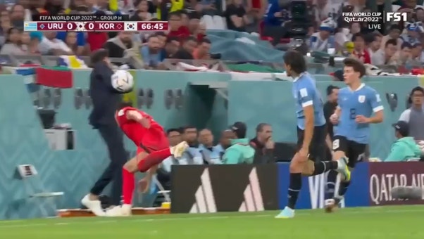 Uruguay coach Diego Alonso gets drilled in the head by an errant touch during match against South Korea.