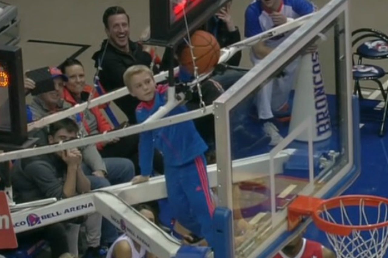 Watch a brave young fan climb above the rim to free basketball stuck