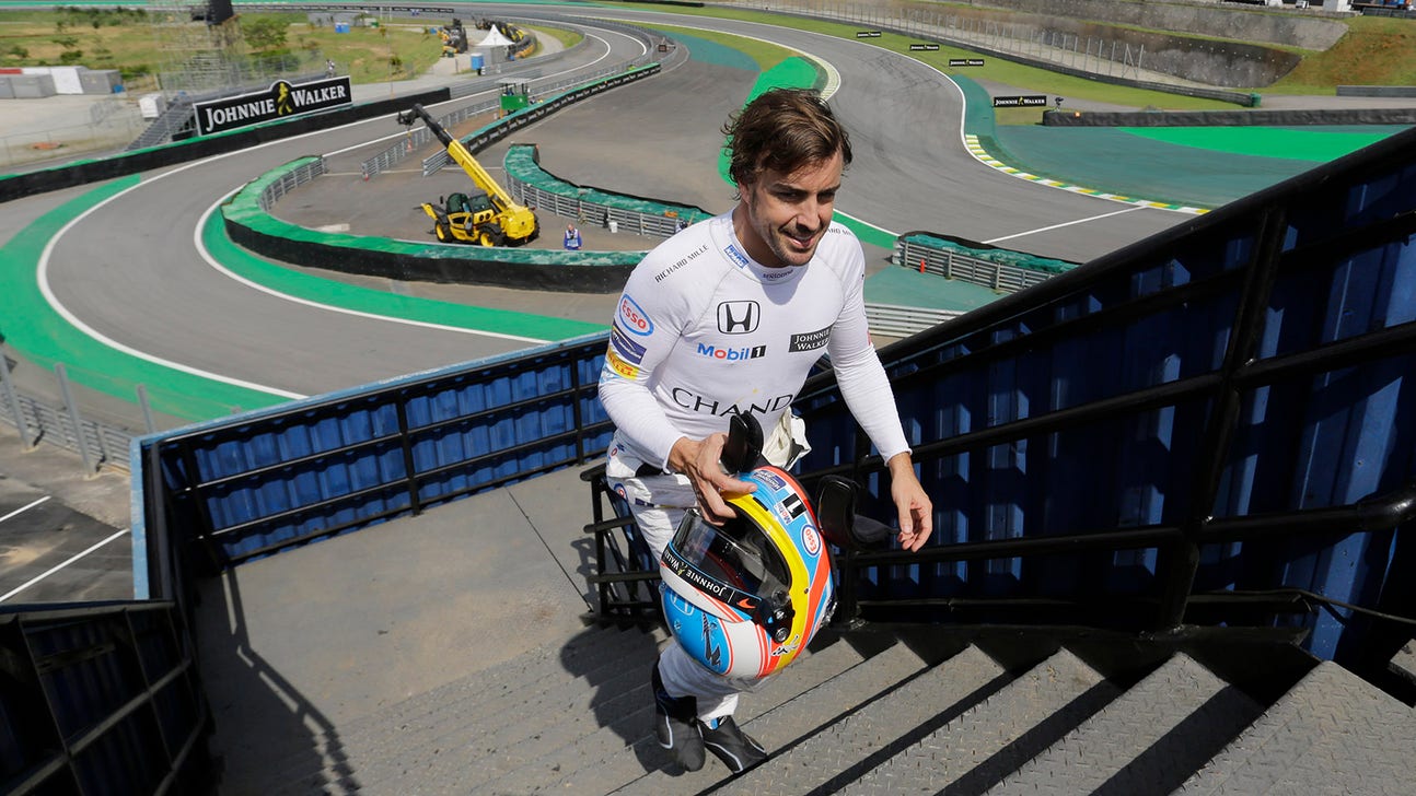 Fernando Alonso operates a camera during F1 practice