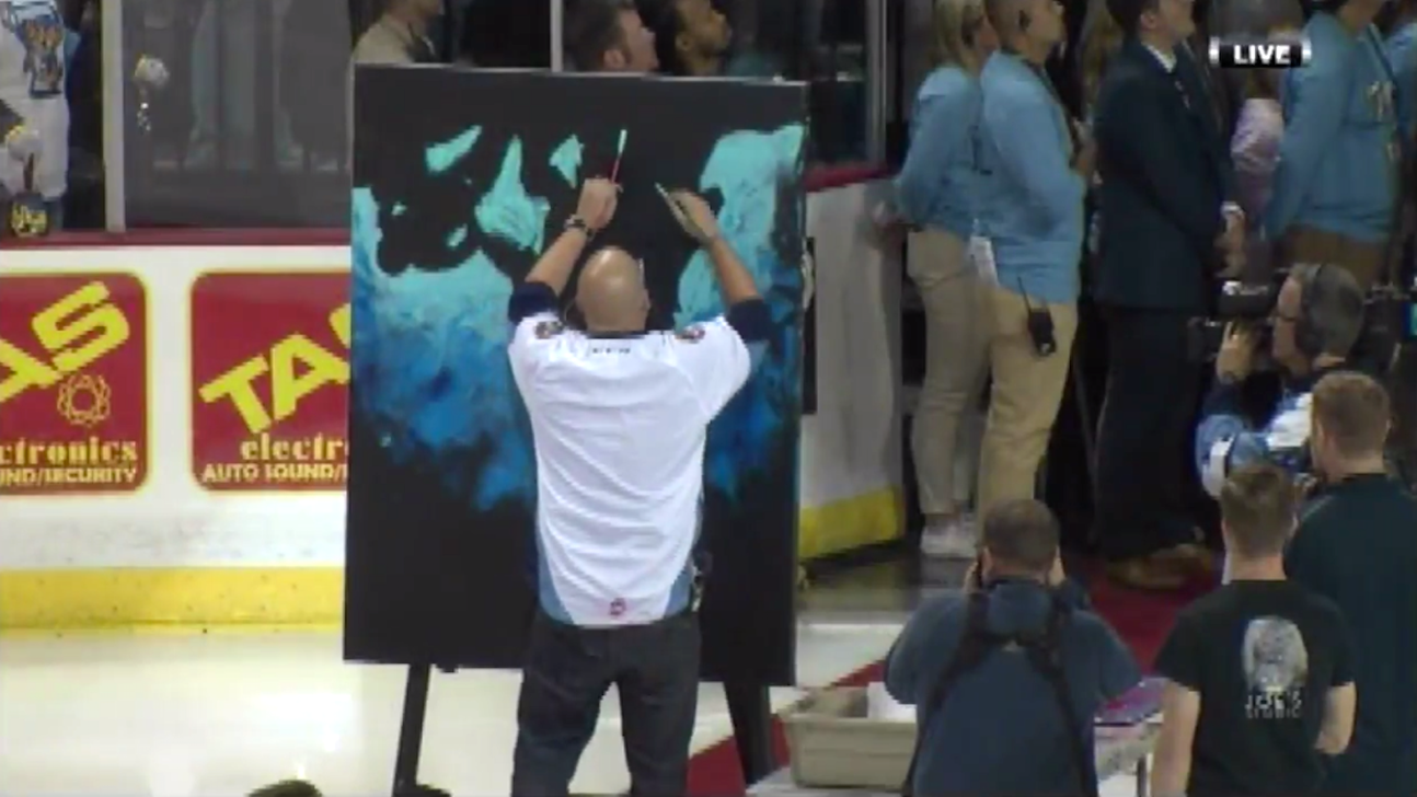 Watch man sing national anthem while painting canvas during hockey game