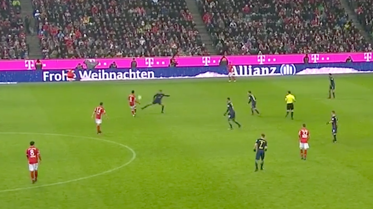 Watch a Bayern Munich player try to pass the ball to a moving Santa ad