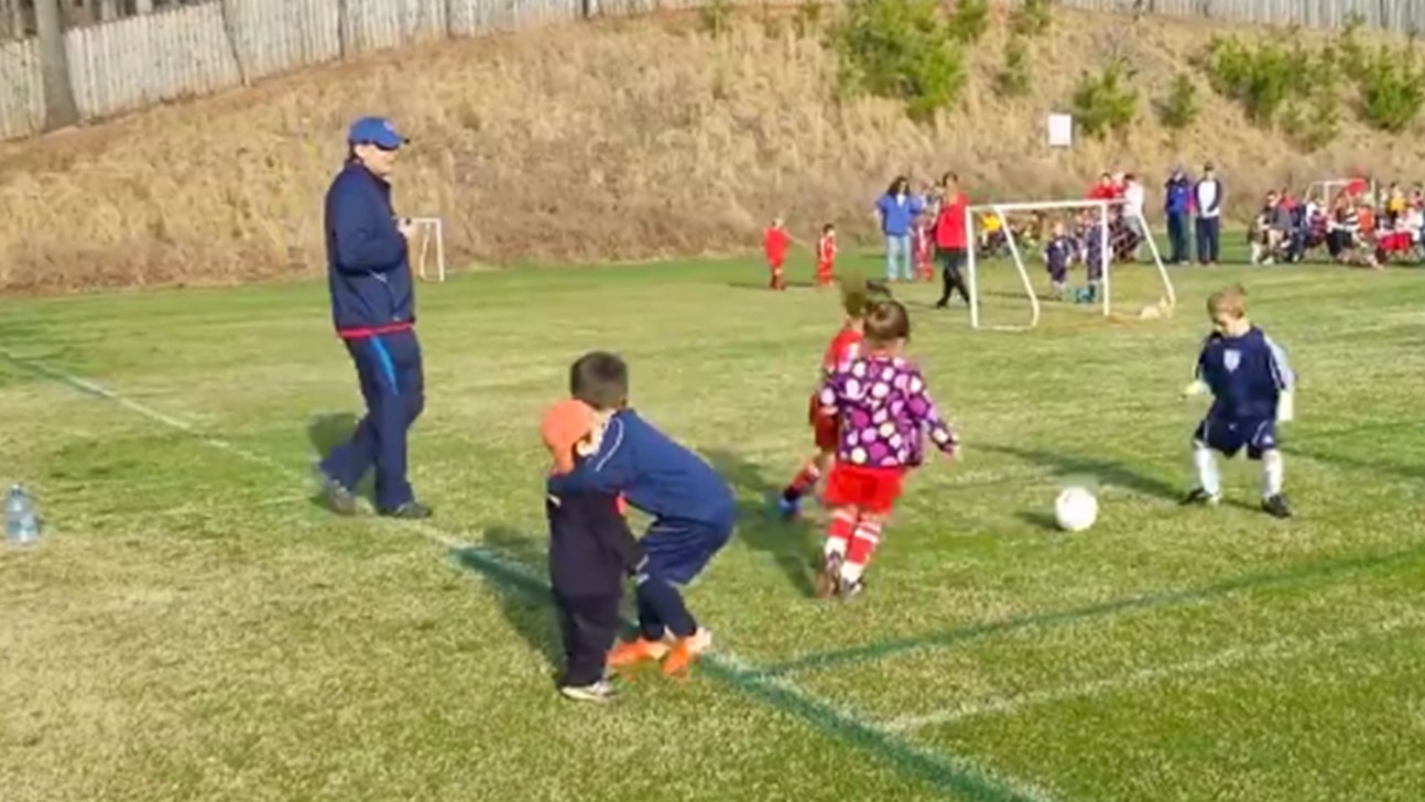 Hug break! Youngster stops mid-game to give his brother a squeeze