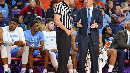 UNC's Roy Williams falls near bench, helped off court