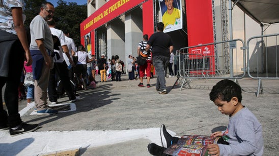 Analog charm of World Cup sticker book endures among fans