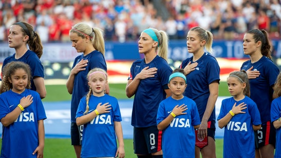 American women hide US Soccer logo during anthem in protest