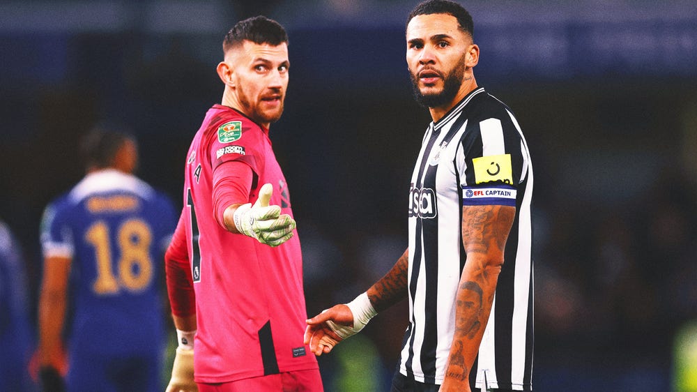 Newcastle GK Martin Dubravka confronted by a fan on the field at Chelsea