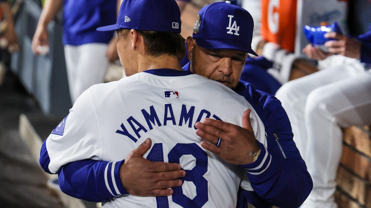 Dodgers manager Dave Roberts embraces pitcher Yoshinobu Yamamoto after holding the Yankees to one run in Game two of the World Series at Dodger Stadium. (Robert Gauthier/Los Angeles Times via Getty Images)
