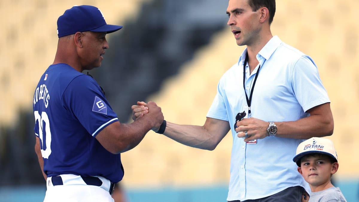 Joe Davis, conversing with Dodgers manager Dave Roberts, has called the team's games for 10 seasons and became the lead MLB on FOX broadcaster in 2022. (Photo by Harry How/Getty Images)