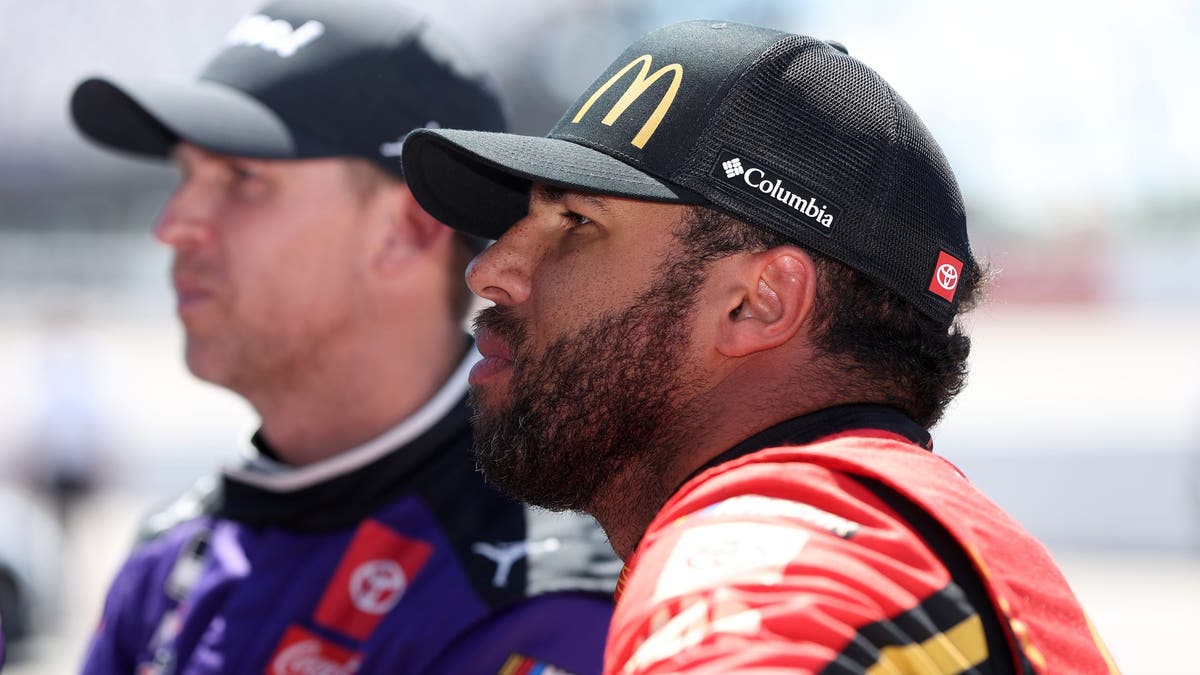 Bubba Wallace and Denny Hamlin look on during qualifying for the the NASCAR Cup Series Goodyear 400 at Darlington Raceway 