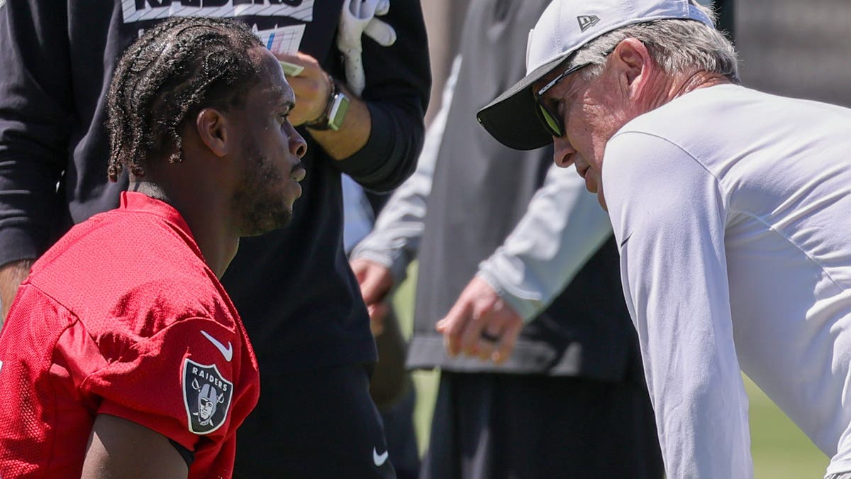 Geno Smith #7 of the Las Vegas Raiders stretches as he talks with head coach Pete Carroll during an OTA offseason workout at the Las Vegas Raiders Headquarters/Intermountain Healthcare Performance Center on May 21, 2025 in Henderson, Nevada. (Photo by Ethan Miller/Getty Images)