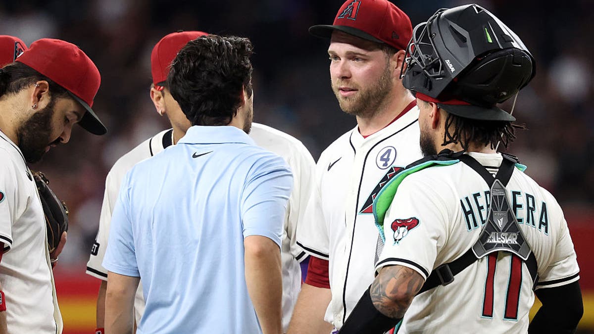 Starting pitcher Corbin Burnes #39 of the Arizona Diamondbacks talks with with assistant athletic trainer Max Esposito before being removed from the game during the fifth inning against the Washington Nationals at Chase Field on June 01, 2025 in Phoenix, Arizona. The Diamondbacks defeated the Nationals 3-1, but lost their ace in the process. (Photo by Chris Coduto/Getty Images)