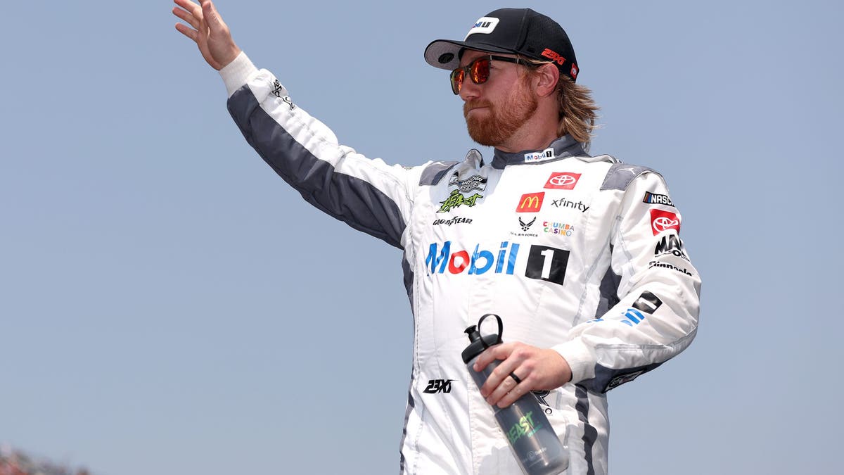 Tyler Reddick waves to fans as he walks onstage during driver intros prior to the NASCAR Cup Series FireKeepers Casino 400 at Michigan?
