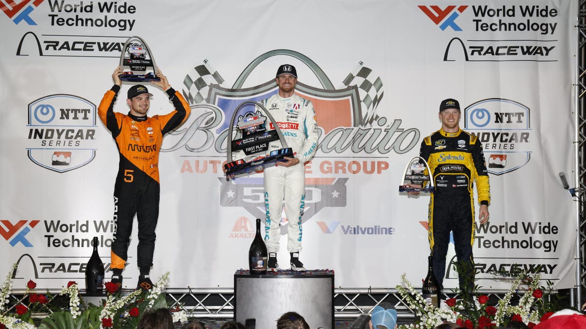 Winner Kyle Kirkwood is joined by Pato O'Ward (left) and Christian Rasmussen (right) on the podium after the Bommarito Automotive Group 500.