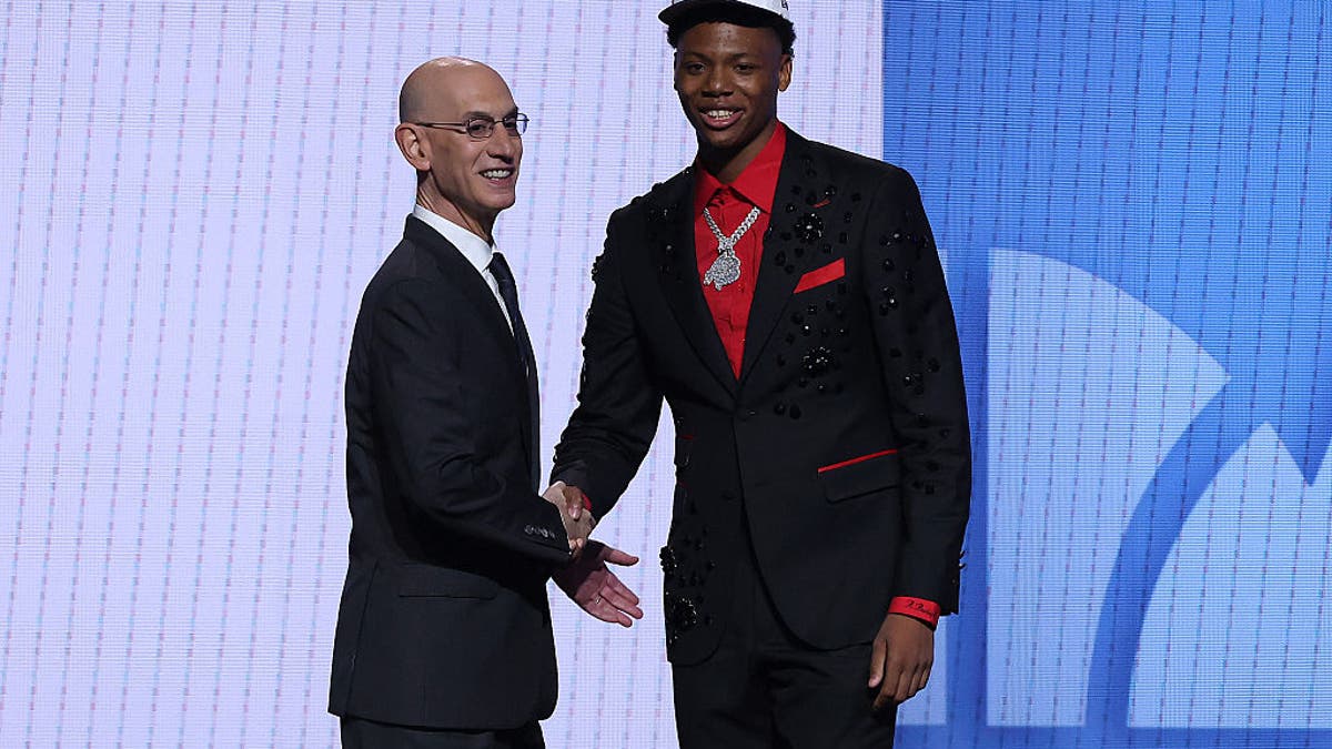 Ace Bailey (R) shakes hands with NBA commissioner Adam Silver (L) after being drafted fifth overall by the Utah Jazz during the first round of the 2025 NBA Draft at Barclays Center on June 25, 2025 in the Brooklyn borough of New York City. (Photo by Sarah Stier/Getty Images).