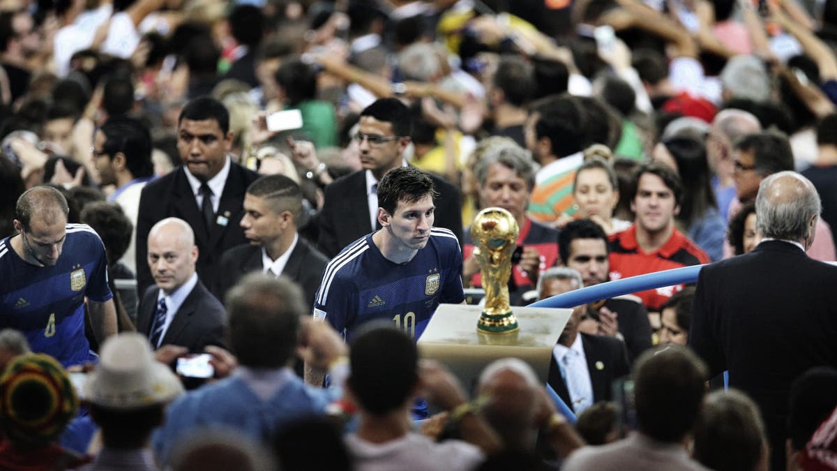Lionel Messi walks past the World Cup trophy after losing the final to Germany in 2014. (Photo by Chengdu Economic Daily/VCG via Getty Images)