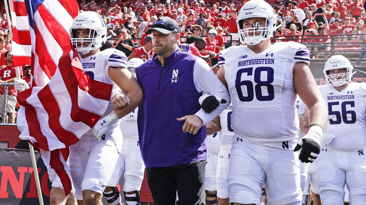 Northwestern head coach David Braun walks out onto the field before a college football game against Rutgers. (Photo by Rich Schultz/Getty Images)
