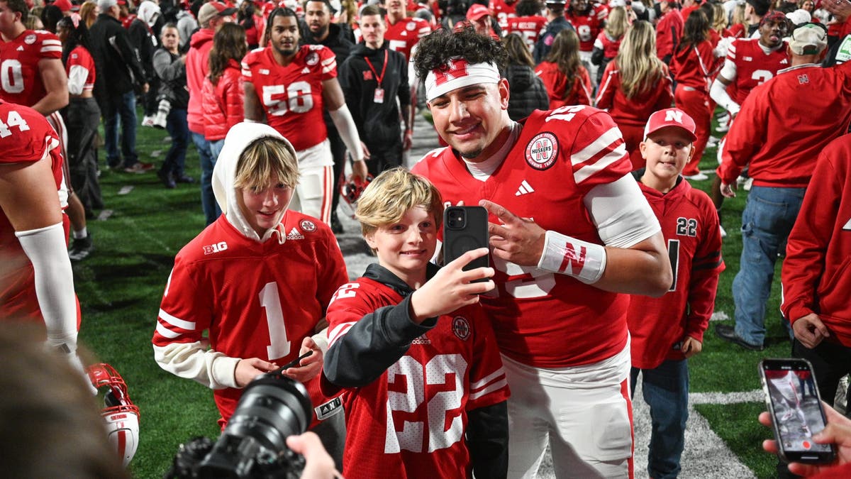 Dylan Raiola #15 of the Nebraska Cornhuskers takes photos with fans after a win against Wisconsin. ?(Photo by Steven Branscombe/Getty Images)