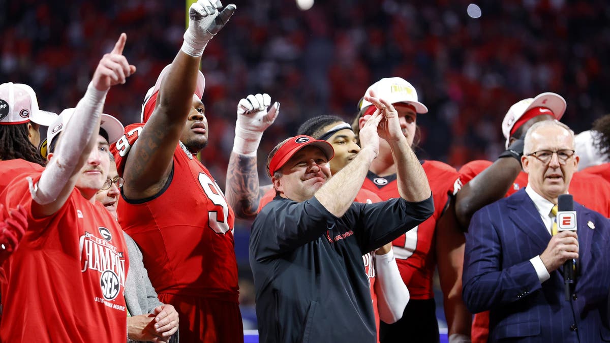 Georgia head coach Kirby Smart and players celebrate after defeating the Texas Longhorns 22-19 in overtime of the 2024 SEC Championship. (Photo by Todd Kirkland/Getty Images)