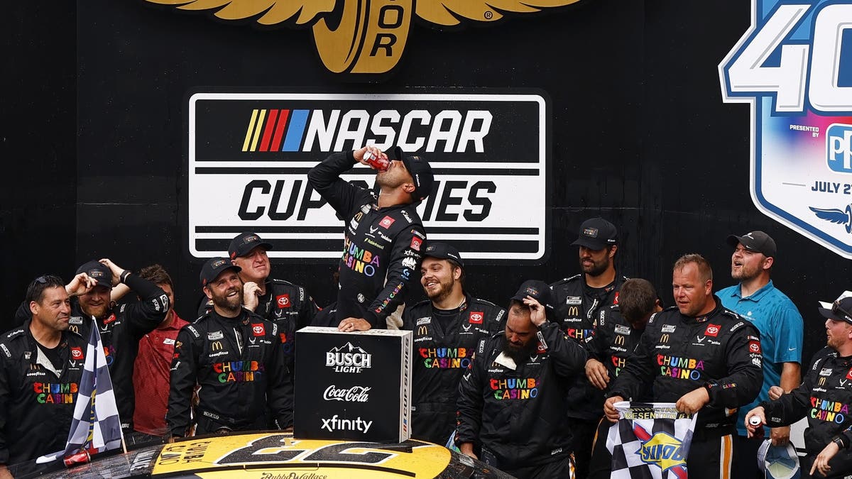 Bubba Wallace chugs a coke after winning the Brickyard 400