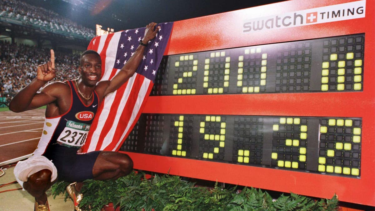Michael Johnson of the USA poses next to his new world record time of 19.32 seconds in the men's 200 meters during Centennial Olympic Games at Olympic Stadium in Atlanta, Georgia. (via Getty Images)