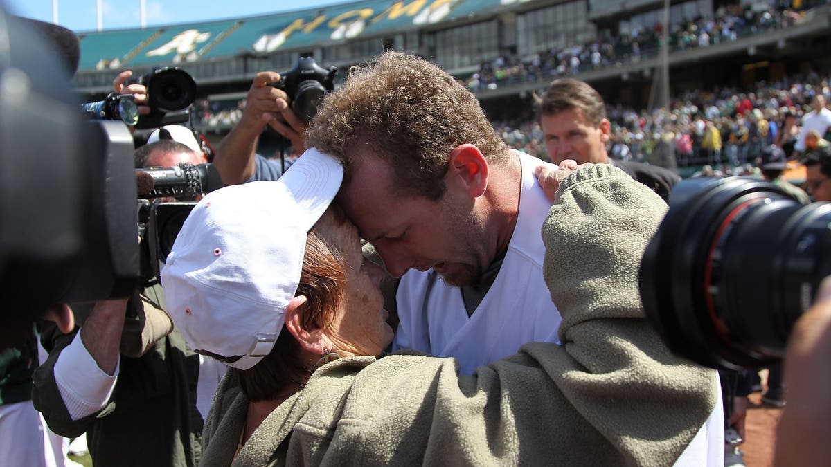 Dallas Braden shared an emotional embrace with his grandmother after throwing a perfect game on Mother's Day in 2010. (Photo by Jed Jacobsohn/Getty Images)